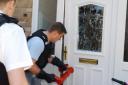 Drugs raid: Police batter the door to gain entry to a house in Artists Way, Andover.