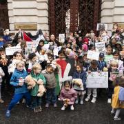 Parents and children lay out cuddly toys across the entrance to the Foreign Office in London, as they protest to save children's lives in Gaza