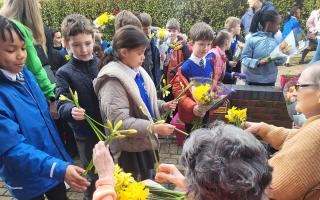 Children give bunches of spring flowers to the residents at Ashbourne Court Care Home