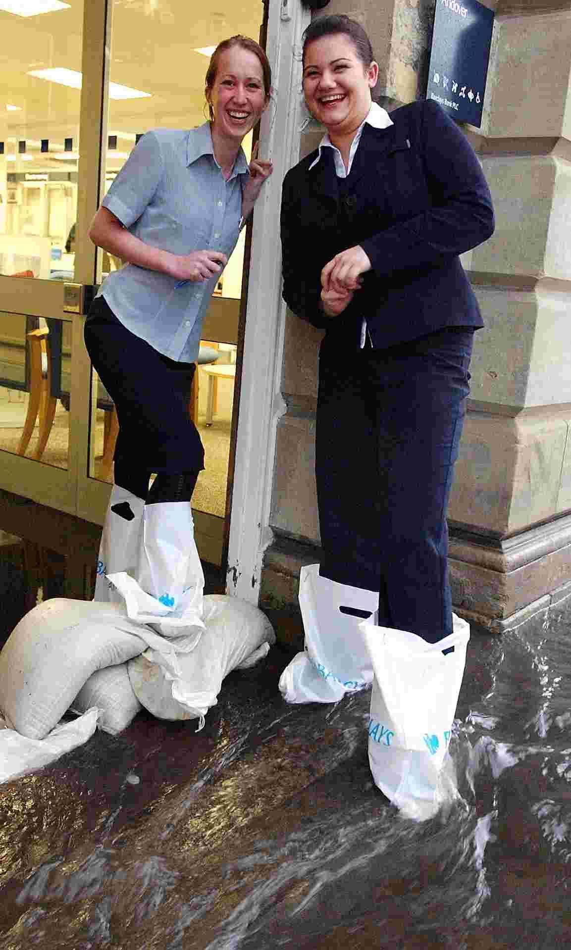 Andover High Street's Barclays Bank employees Rebecca Greenway and Emily Tattershall wearing barclays bank bags on their feet due to flooding in the entrance lobby. in 2007