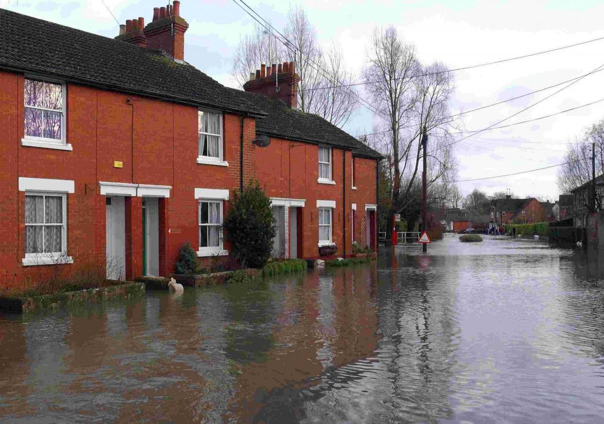 Flood water flows down the centre of Shipton Bellinger after the River Bourne burst its banks. - 2003