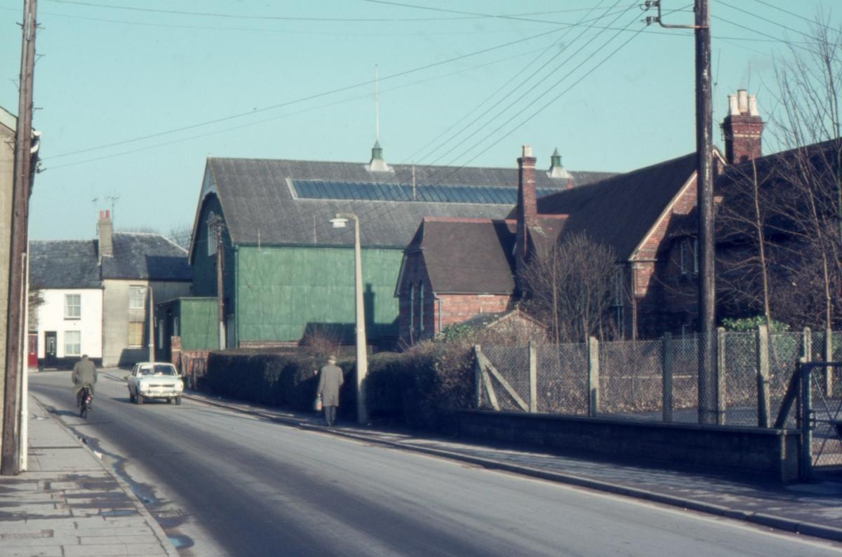 East Street, where the school located there remains open with the Drill Hall (green 'tin' building) which became the Country Bumpkin Club in the early 1970s and was destroyed by fire in the early 1980s. The houses in the background were demolished and mad