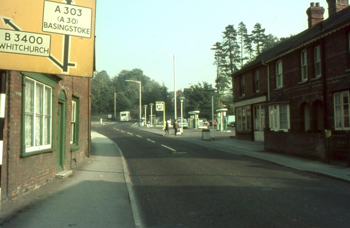 London Street. The houses to the left are now demolished and behind today's hedge plantings lies King's Meadow flats.  The yellow trunk road signage shows the priority at the junction being with the Michedever Road (A303).

Picture from the Jeffrey Saun