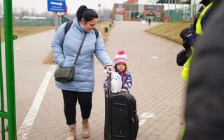 A family crossing the border point from Ukraine into Medyka, Poland. Photo via PA/Victoria Jones.