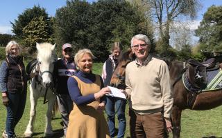 Alex Hanbury-Williams, chair of Andover RDA, accepting the cheque from Andover Chamber Choir Chair Bruce Randall